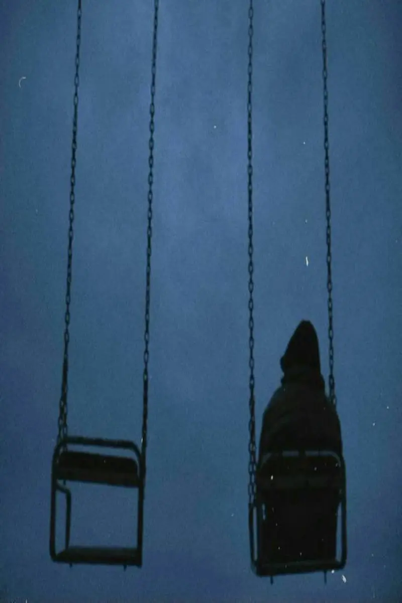 پسری نشسته روی تاب تنها